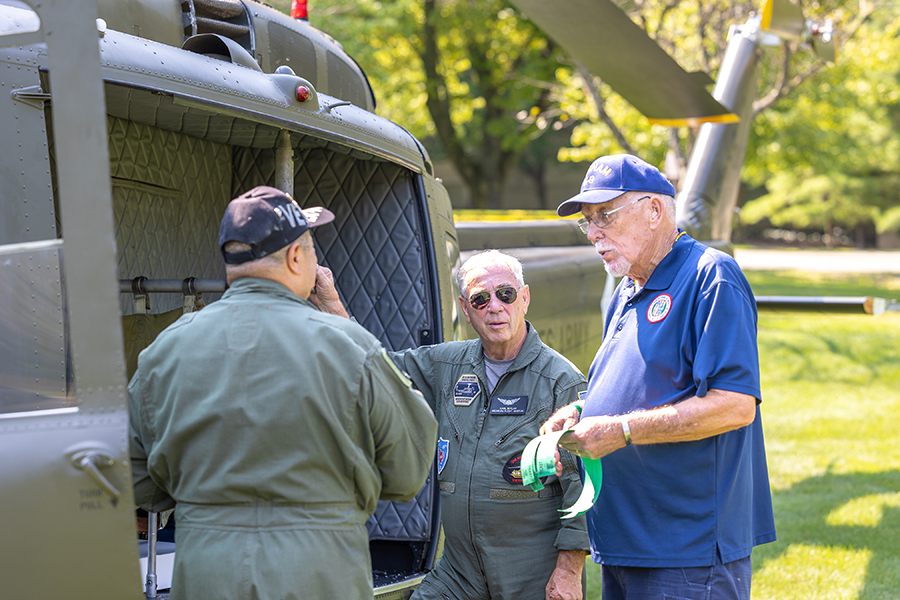 Veterans talk near an Army helicopter