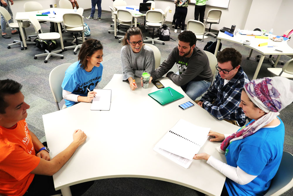 business students working around a table business students working around a table